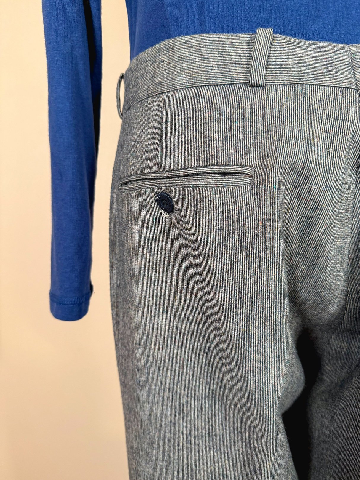 Men's Nino Cerruti trousers in blue with a striped pattern, showcasing a rear pocket and button detail, from the 1980s era.