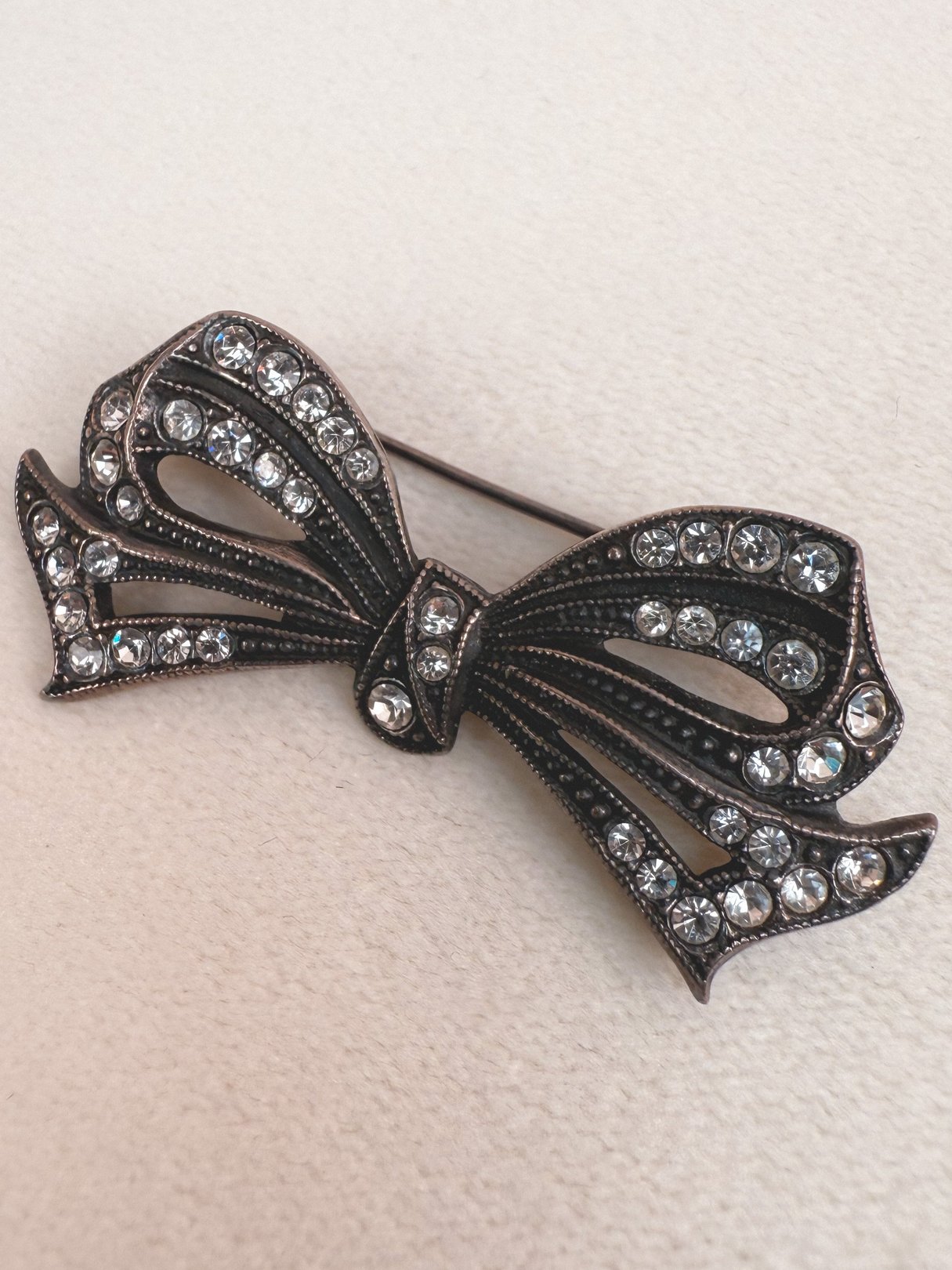 A 1970s silver Deco Bow Pin adorned with multiple sparkling rhinestones.