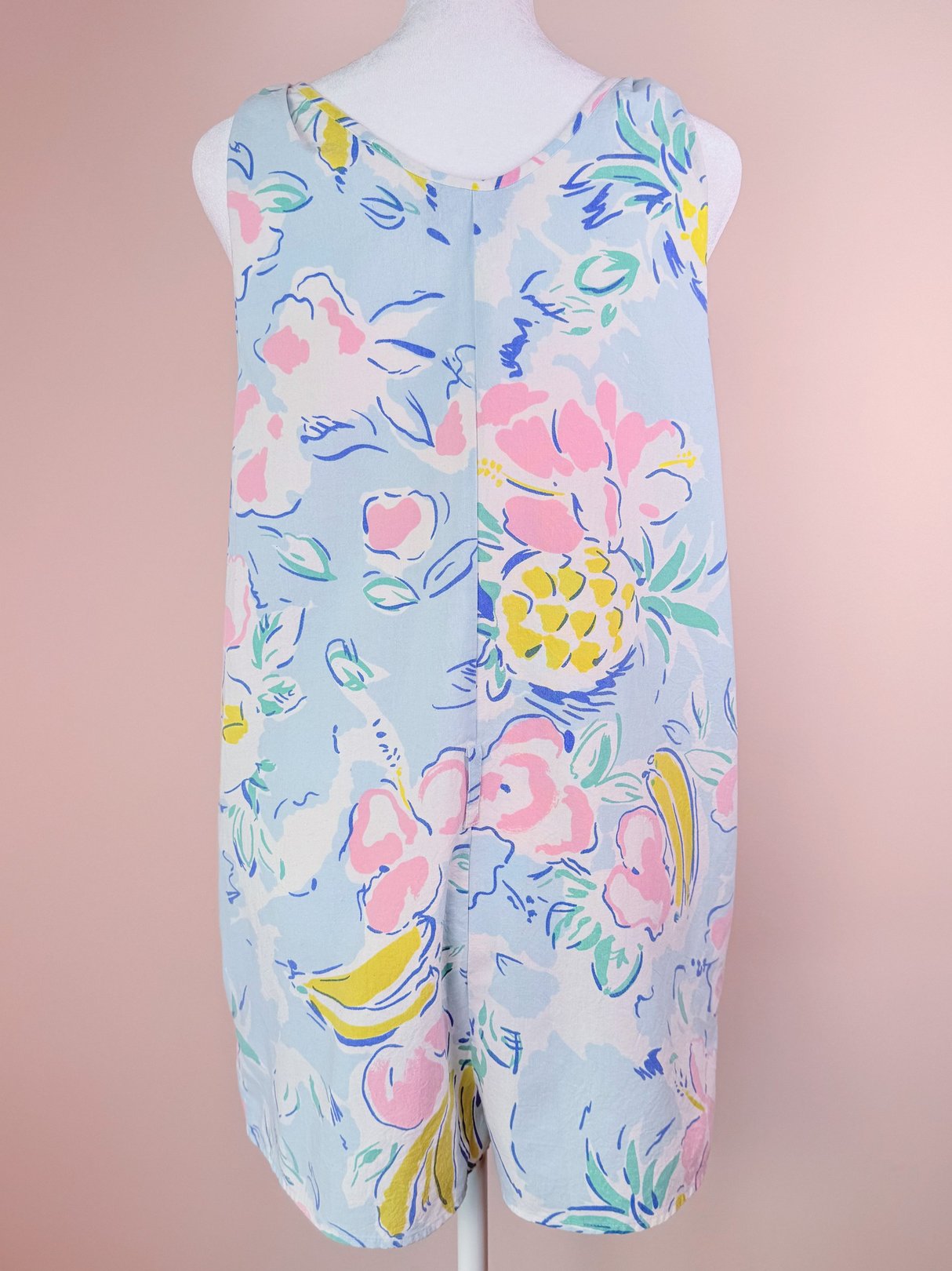 Light blue 1980s romper featuring a vibrant floral print, including pink flowers and yellow pineapples.