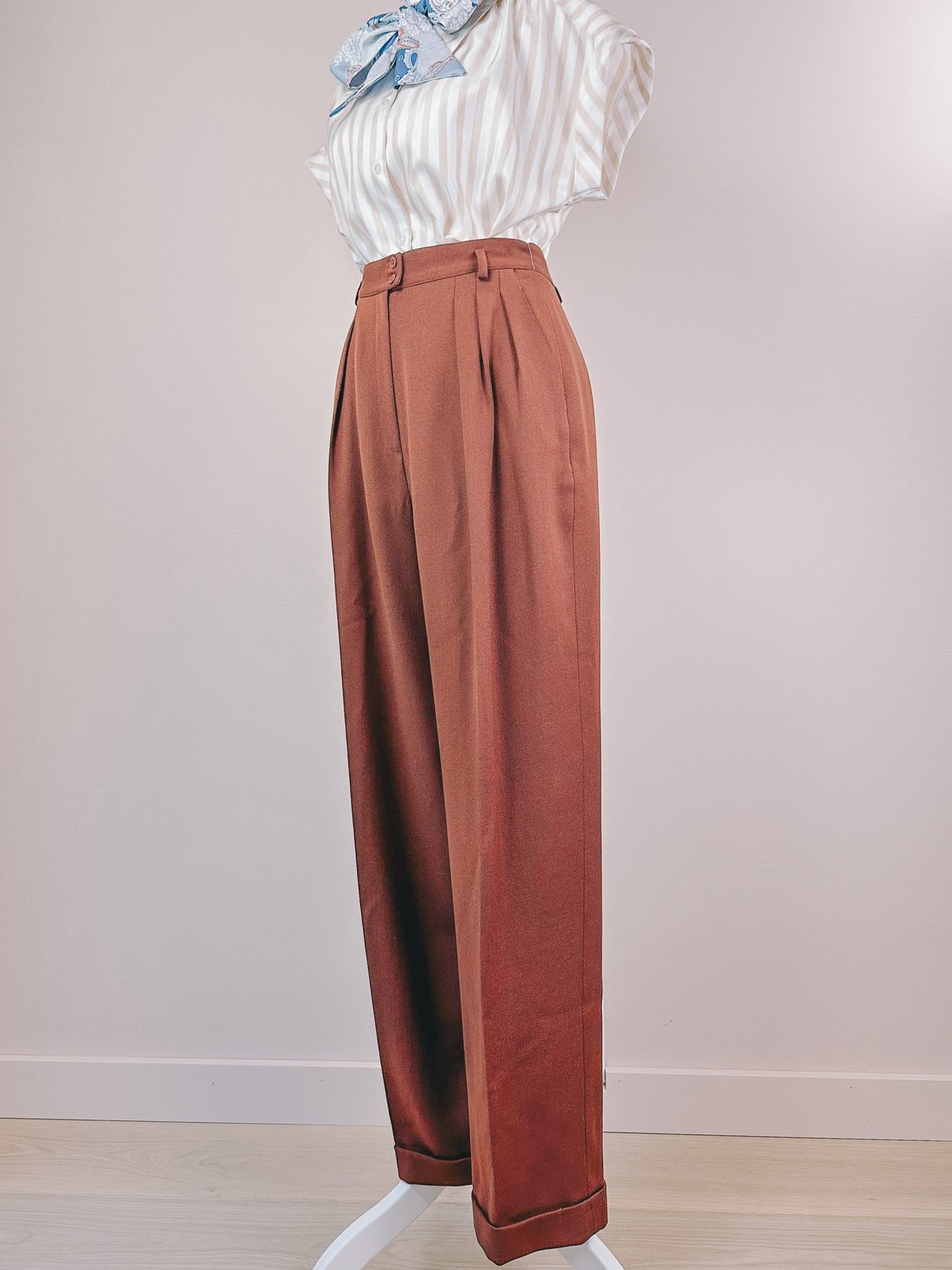 Chestnut women's 1990s Kentucky Downs pants featuring a high waist and pleated design, displayed on a mannequin with a striped blouse and scarf.
