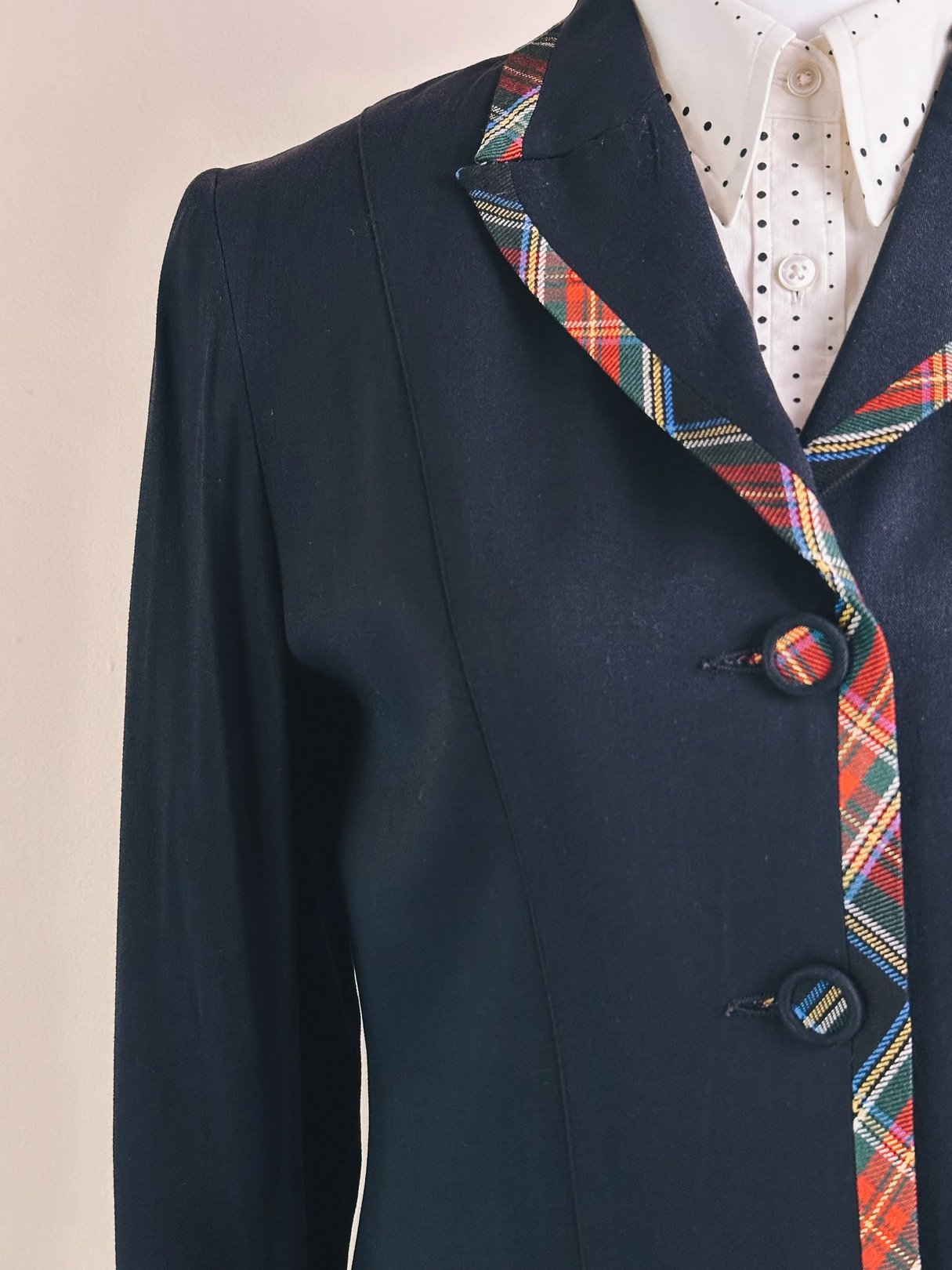 Navy blue blazer with a plaid collar and decorative buttons.