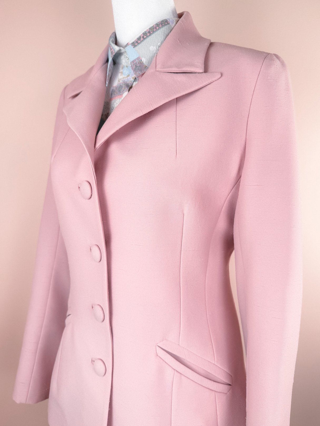 Blush pink women's 1970s three-piece suit featuring a tailored jacket with a notched collar and button closure.