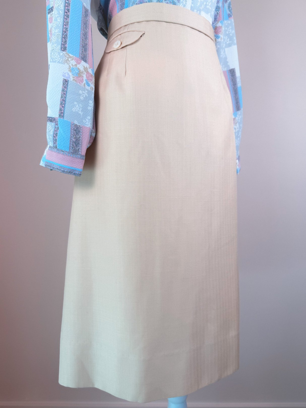 Cream beige 1960s women's skirt with a tailored fit and a side button detail.