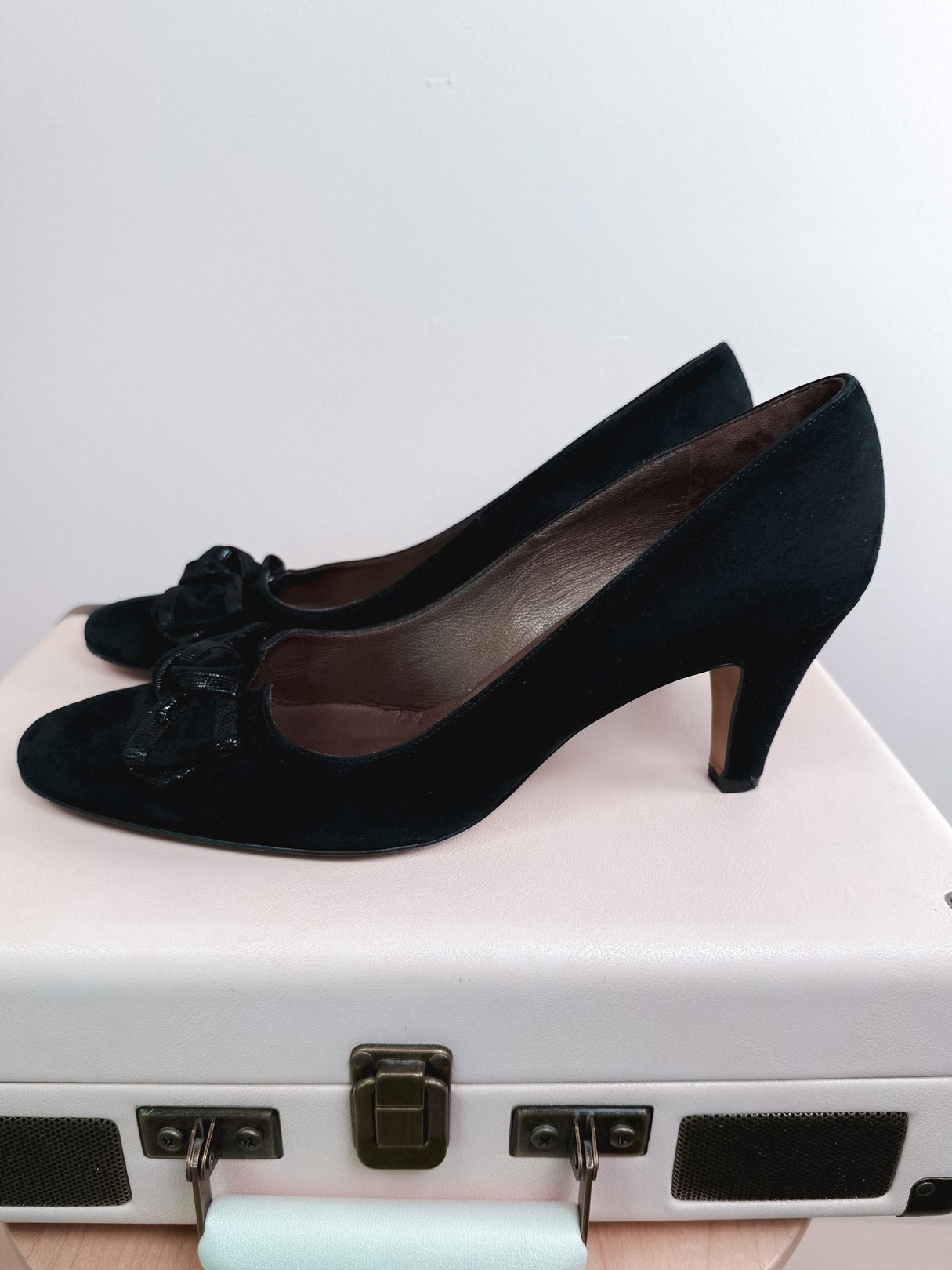 Black suede pumps for women from the 1970s featuring a bow detail and a moderate heel.