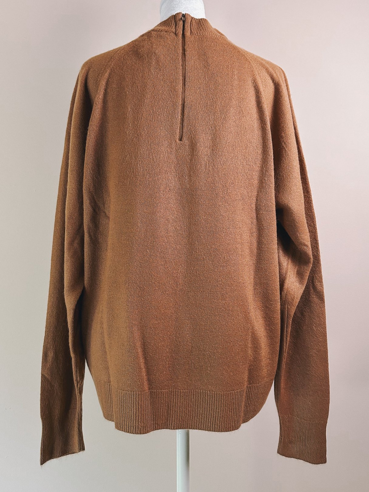 Caramel brown women's sweater with a mock neck and back zipper, styled in a 1960s design.
