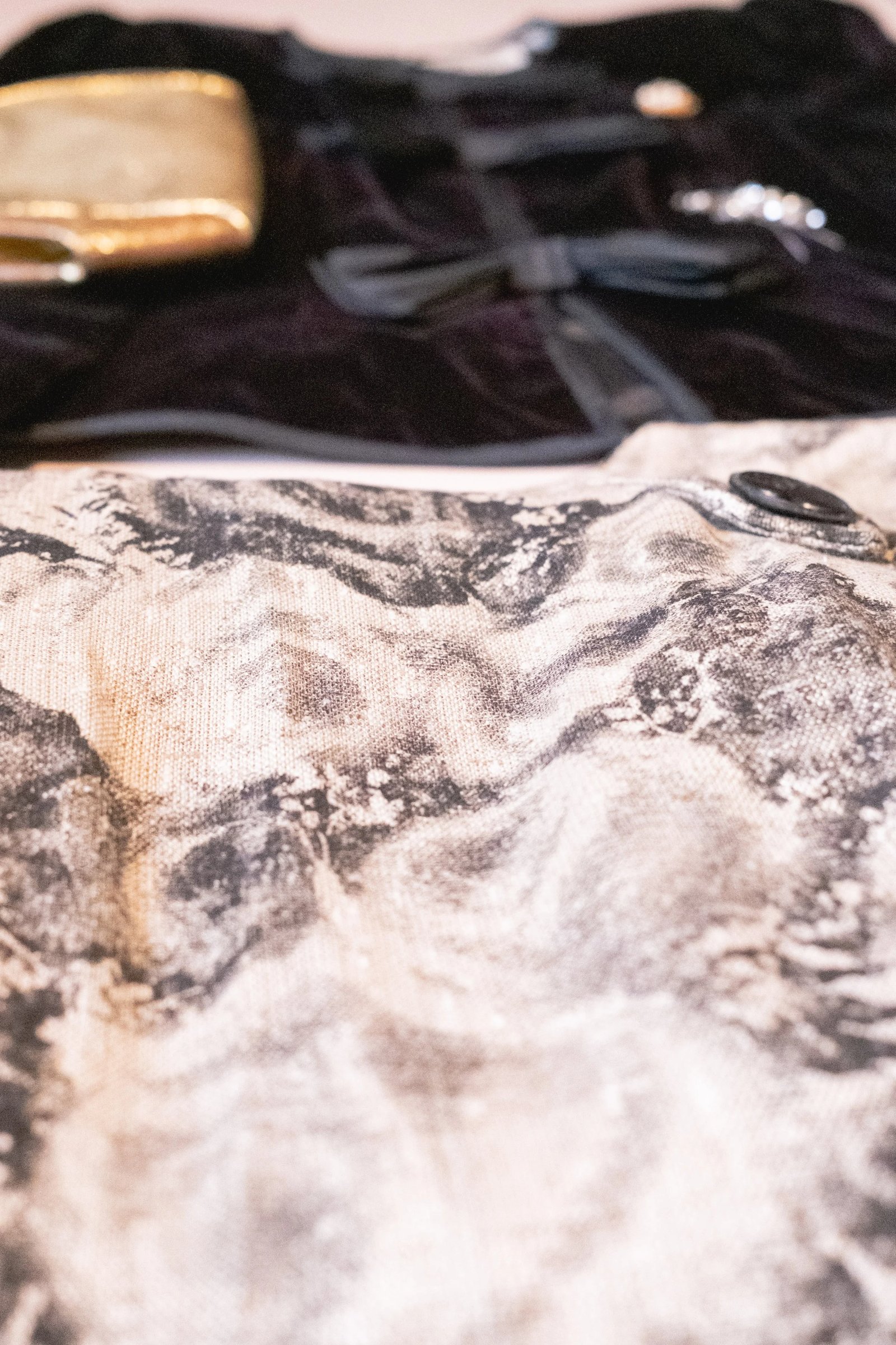 Close-up of a textured fabric with a black and beige abstract pattern featuring rocky, natural shapes.