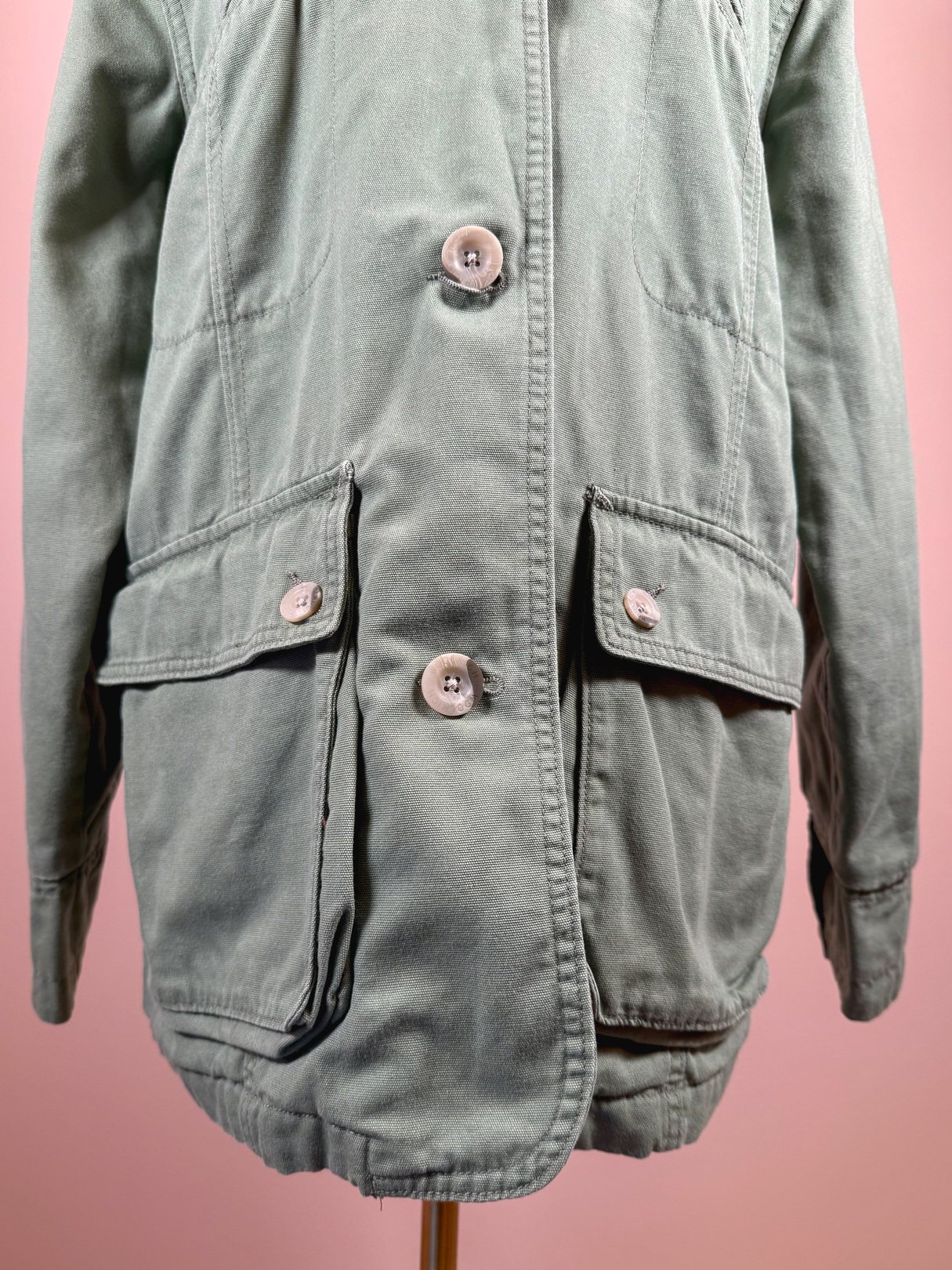 Sage-colored 1970s women's Quilted Woolrich jacket featuring button closures and large front pockets.