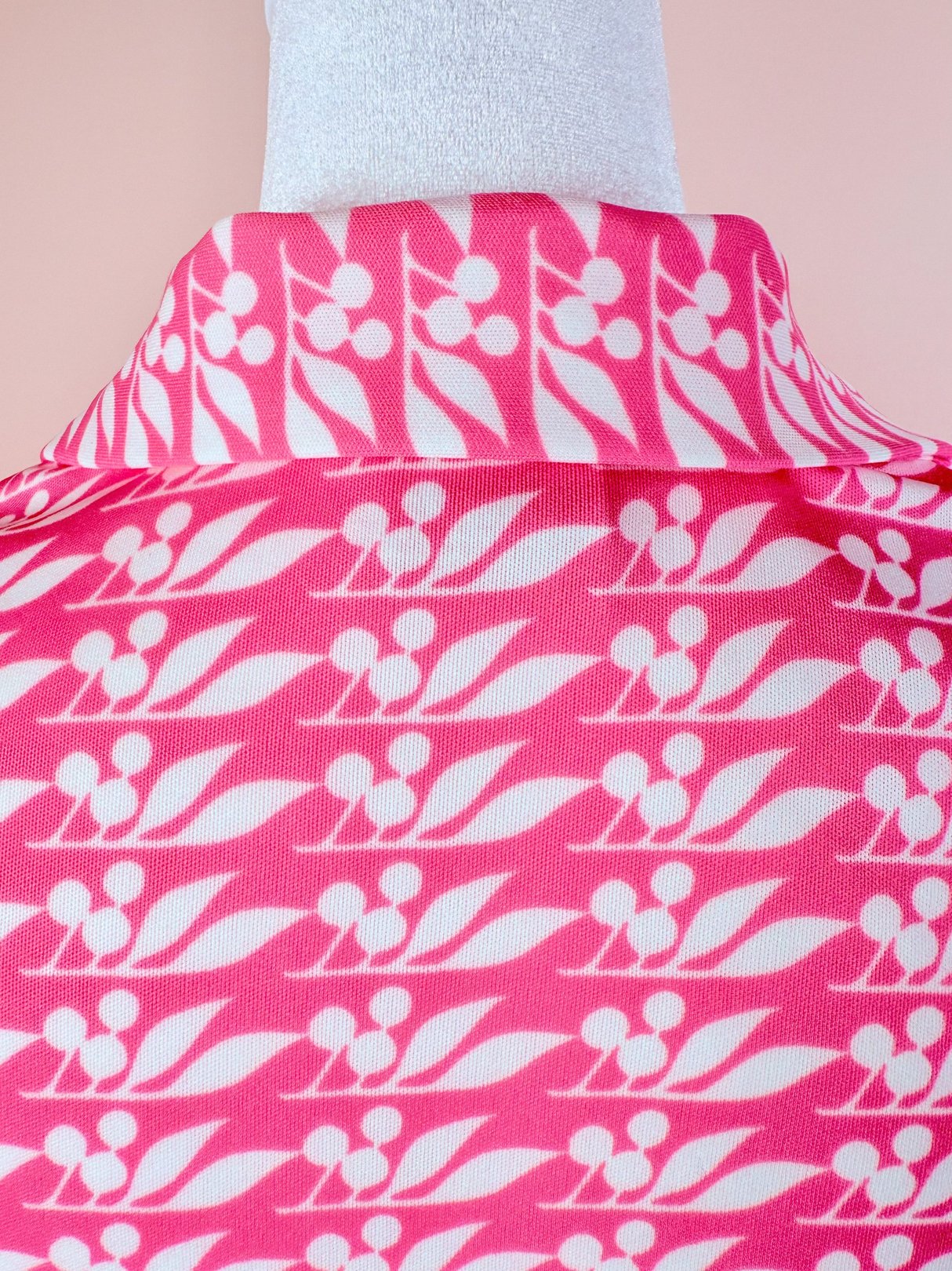 1970s women’s pink blouse featuring a cherry petal pattern.