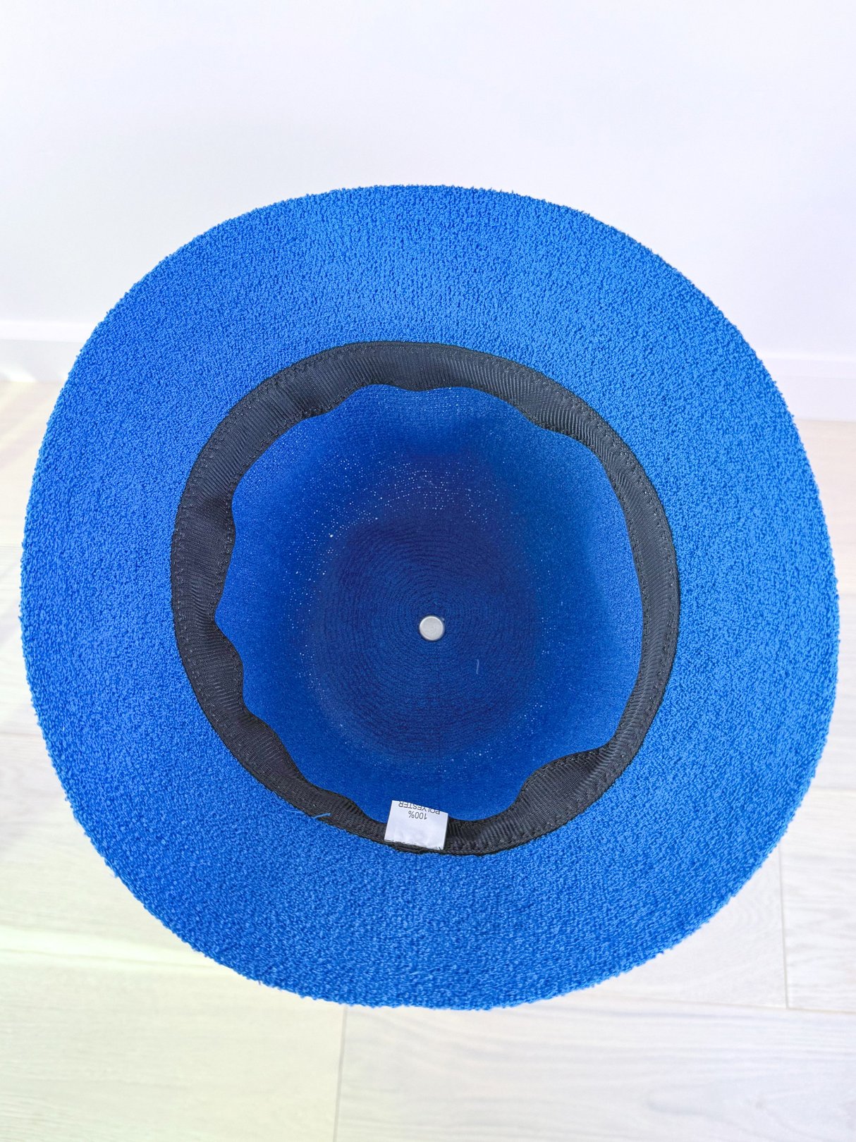 Cobalt blue women’s bucket hat with a textured outer surface and a black inner lining, inspired by 1960s fashion.