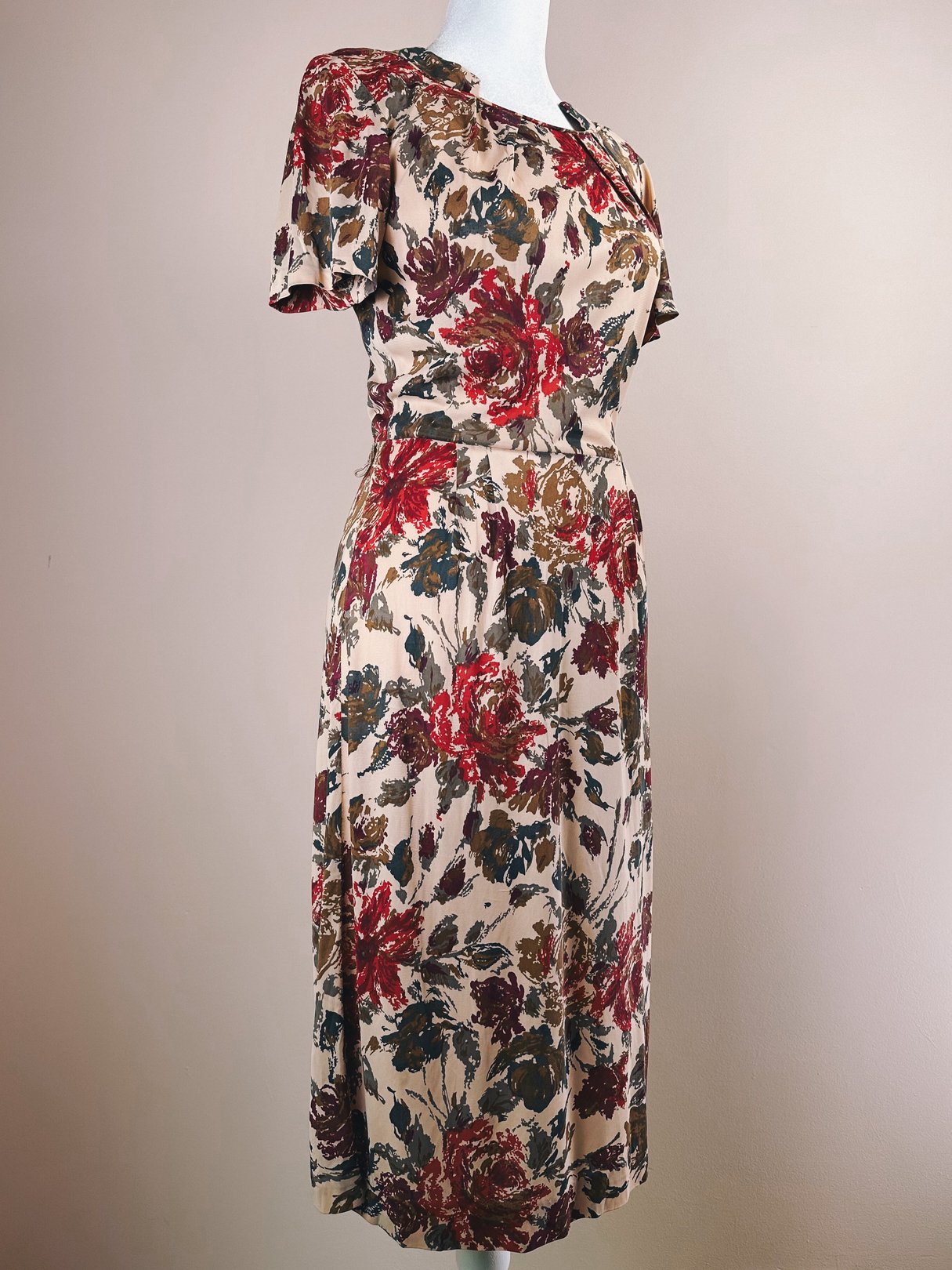 Red floral dress featuring short sleeves and a fitted waist, representing the 1960s style.