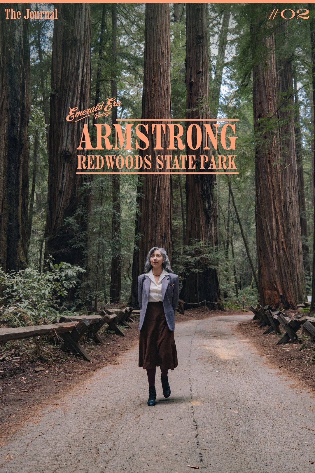A person stands on a path surrounded by tall redwood trees at Armstrong Redwoods State Park.