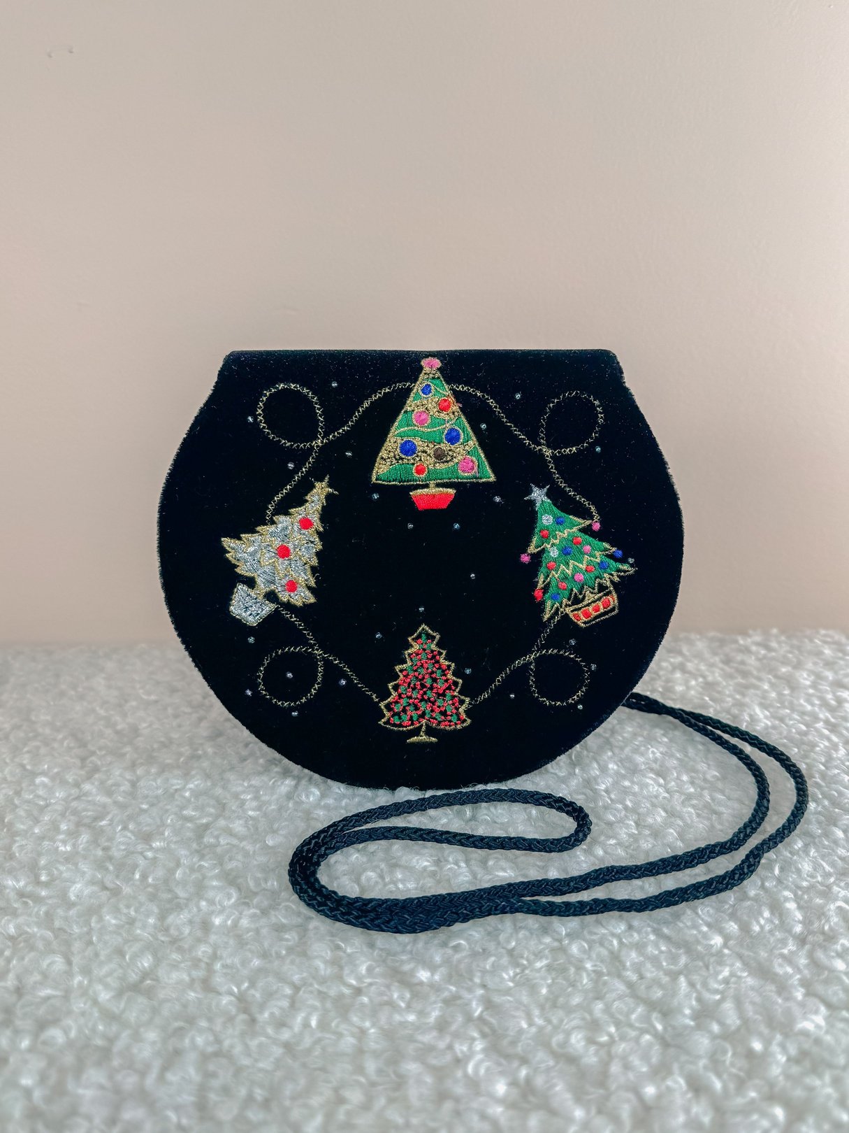 Black velvet purse featuring colorful Christmas tree designs, reflective details, and a shoulder strap, inspired by 1970s style.