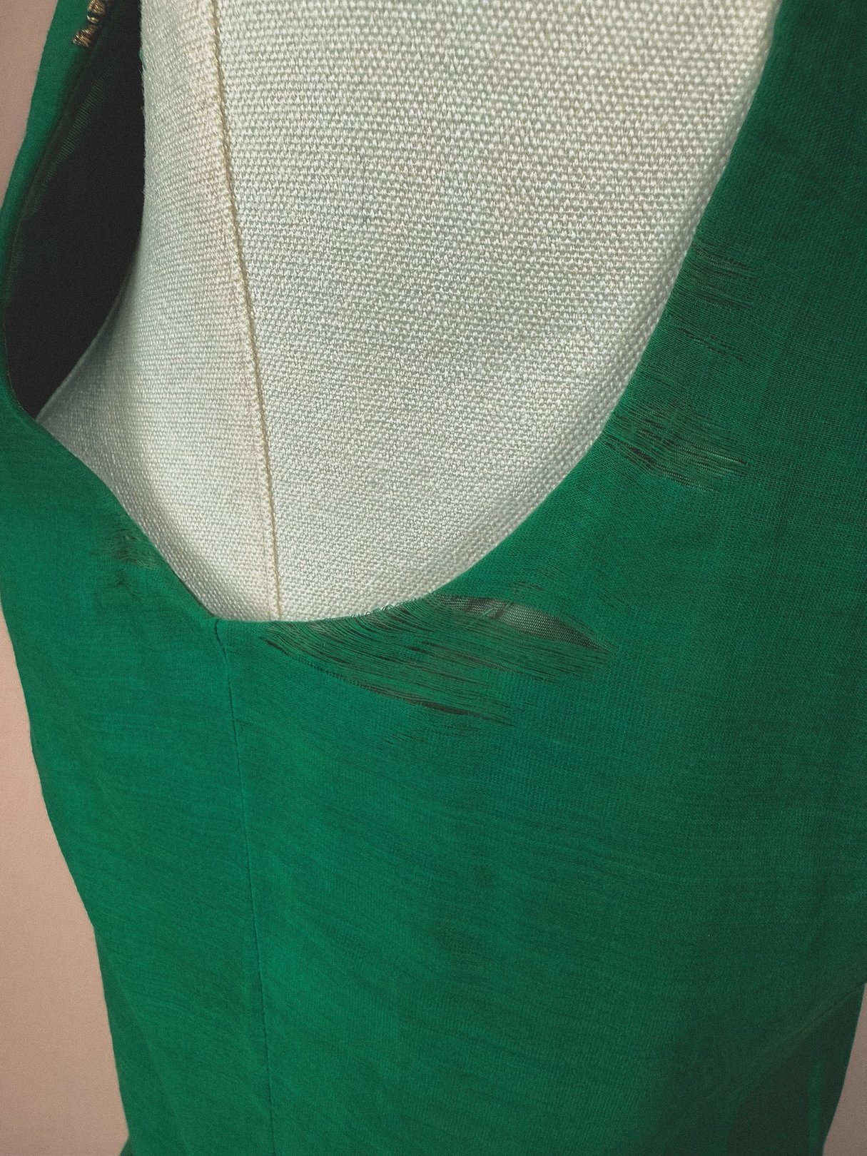 Emerald green 1950s women's dress with a starburst design, featuring a scoop neckline and visible fabric texture.