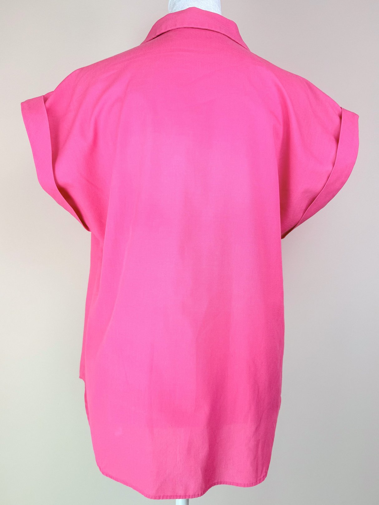 Back view of a women's 1980s pink top with short sleeves.