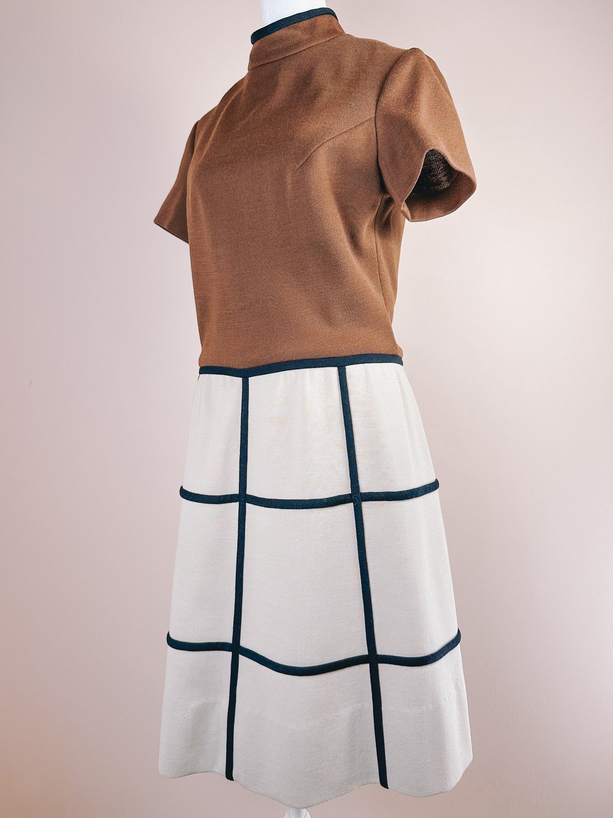 1960s British Mod Squared Dress for women featuring a brown top and a cream skirt with a geometric black trim design.