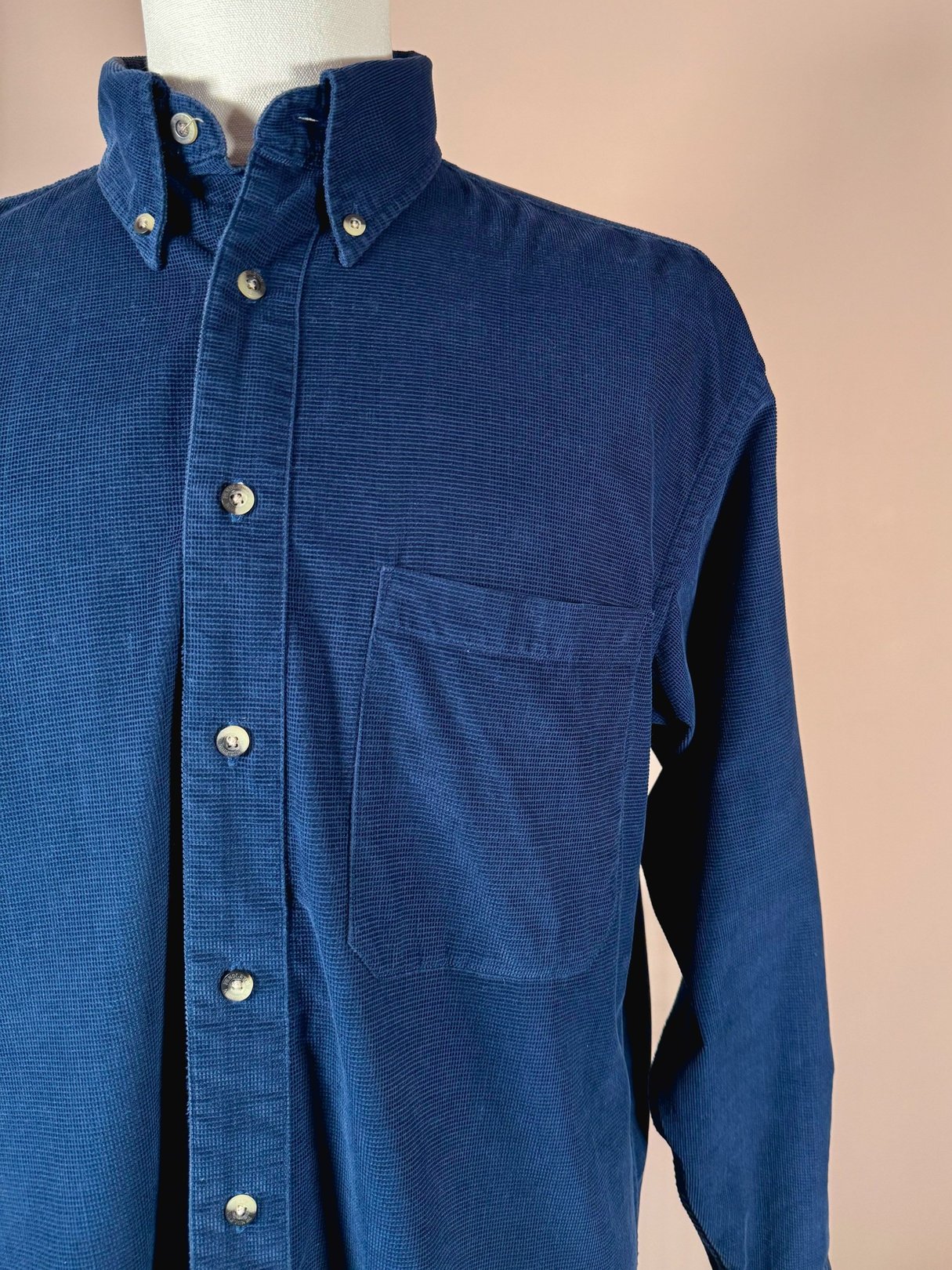 Navy blue men's cord shirt from the 1990s featuring a button-up front and a chest pocket.