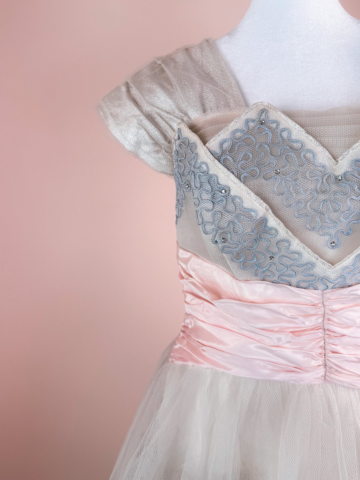 The Twilight Waltz Dress features a silver bodice with intricate blue embroidery and a pink ruched waistband.