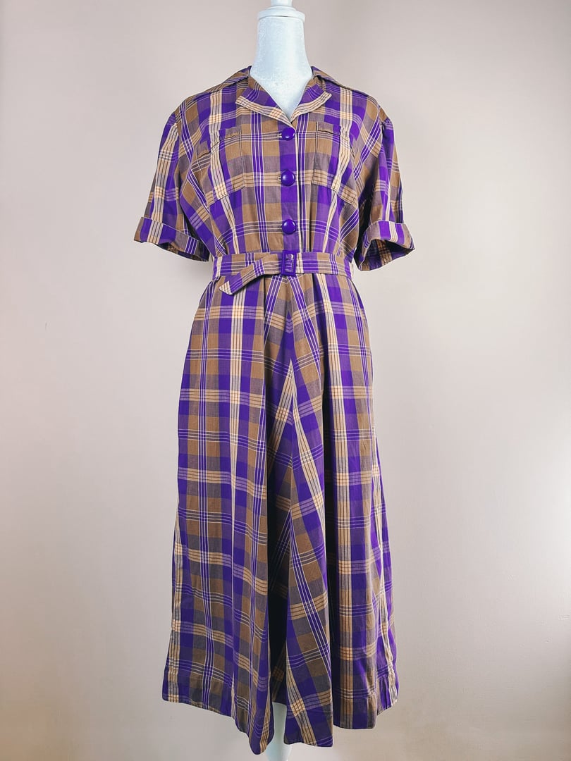 1950s purple plaid retreat dress featuring short sleeves, a collar, and a belted waist.