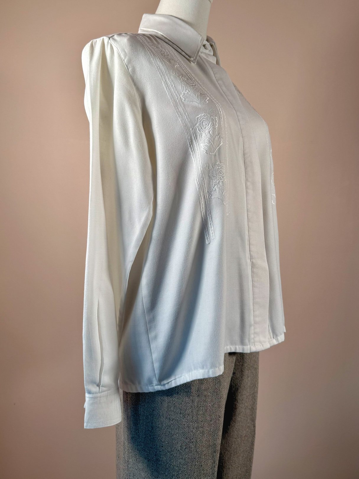 White women's 1970s Cloud Cotton embroidered shirt featuring subtle floral embroidery and a collared neckline, displayed on a mannequin.