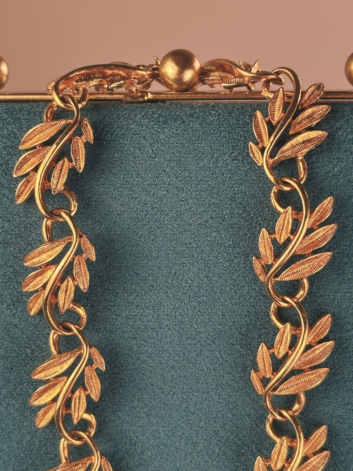 Gold tone collar necklace featuring a swirled vine design, designed for women in the 1970s.
