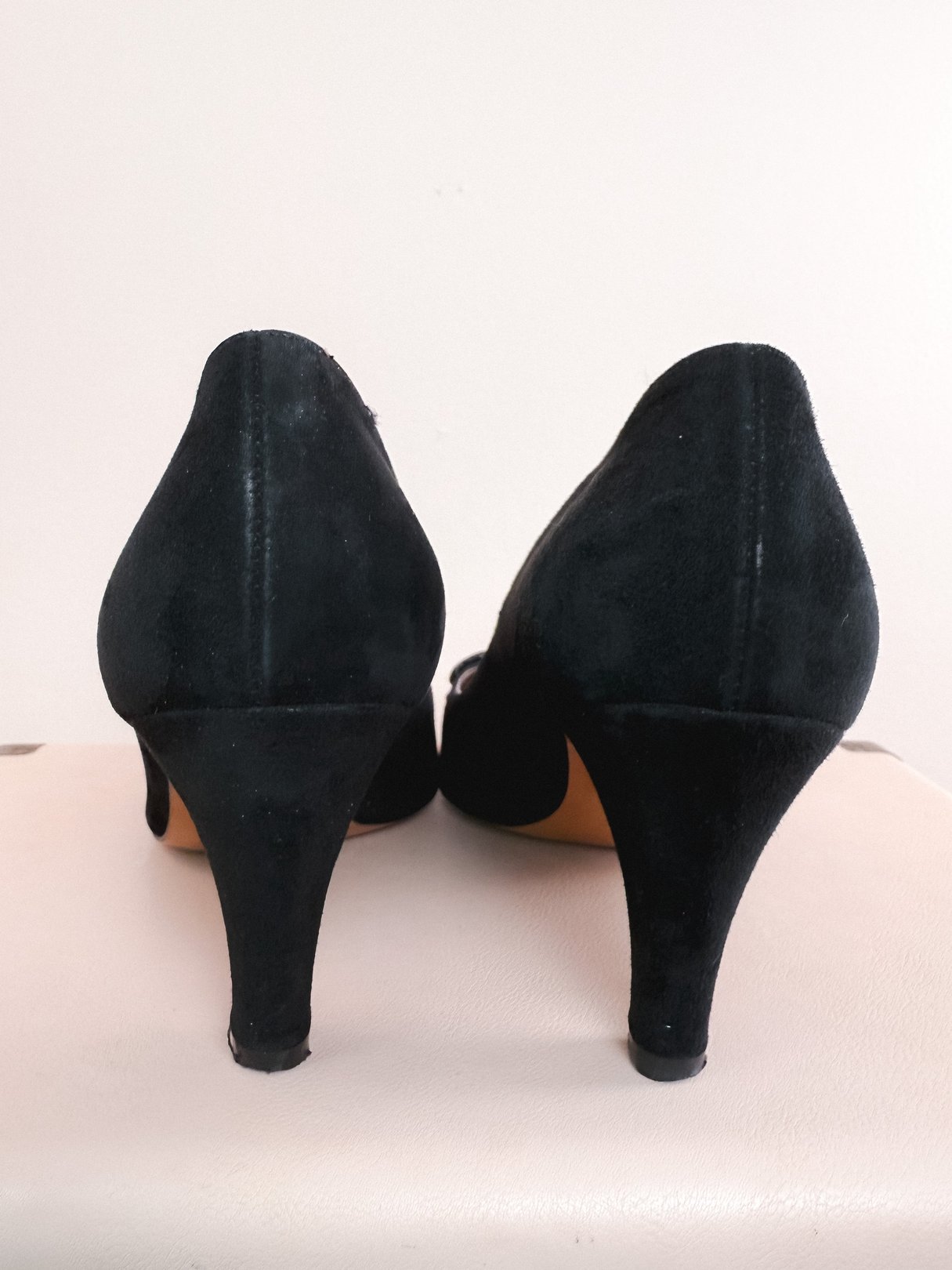 Black suede pumps with a 1970s design and a pointed toe feature a slim high heel.