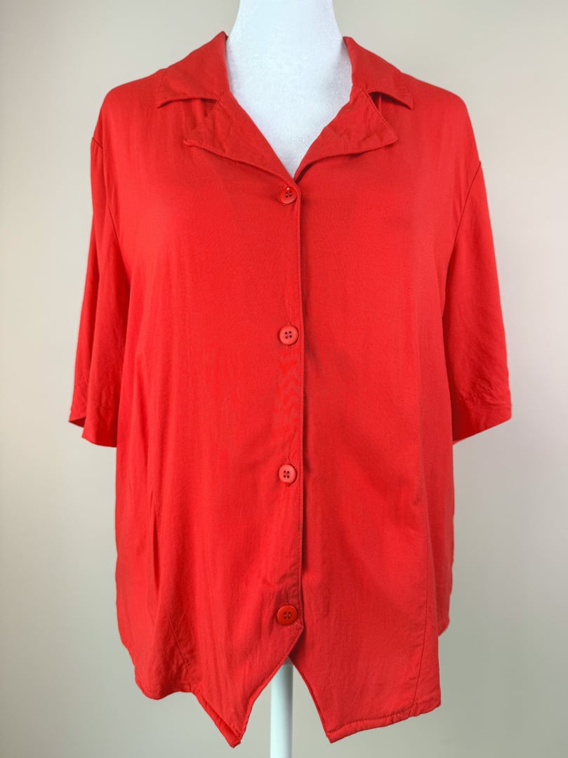 Red 1980s women's top featuring a collared neckline and buttons down the front.