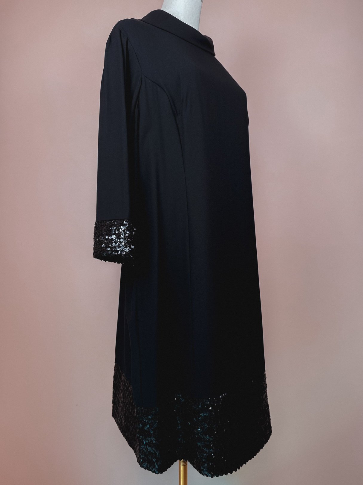 Black 1960s Mod Sparkle Dress featuring a high neckline and sequin embellished hem.