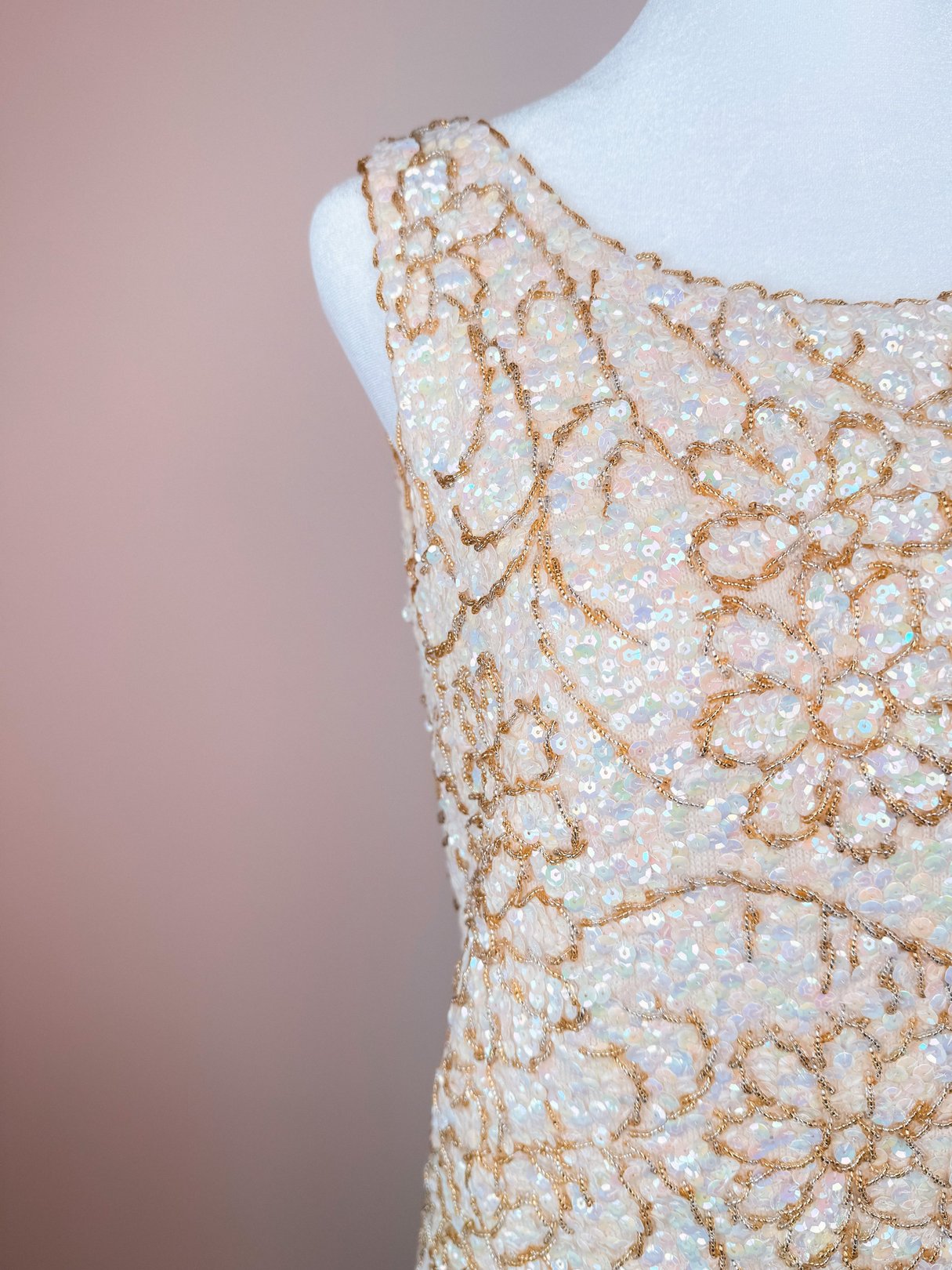 The 1960s Champagne Blossom Top features intricate gold floral sequins on a white base, ideal for women seeking a sparkly addition to their wardrobe.