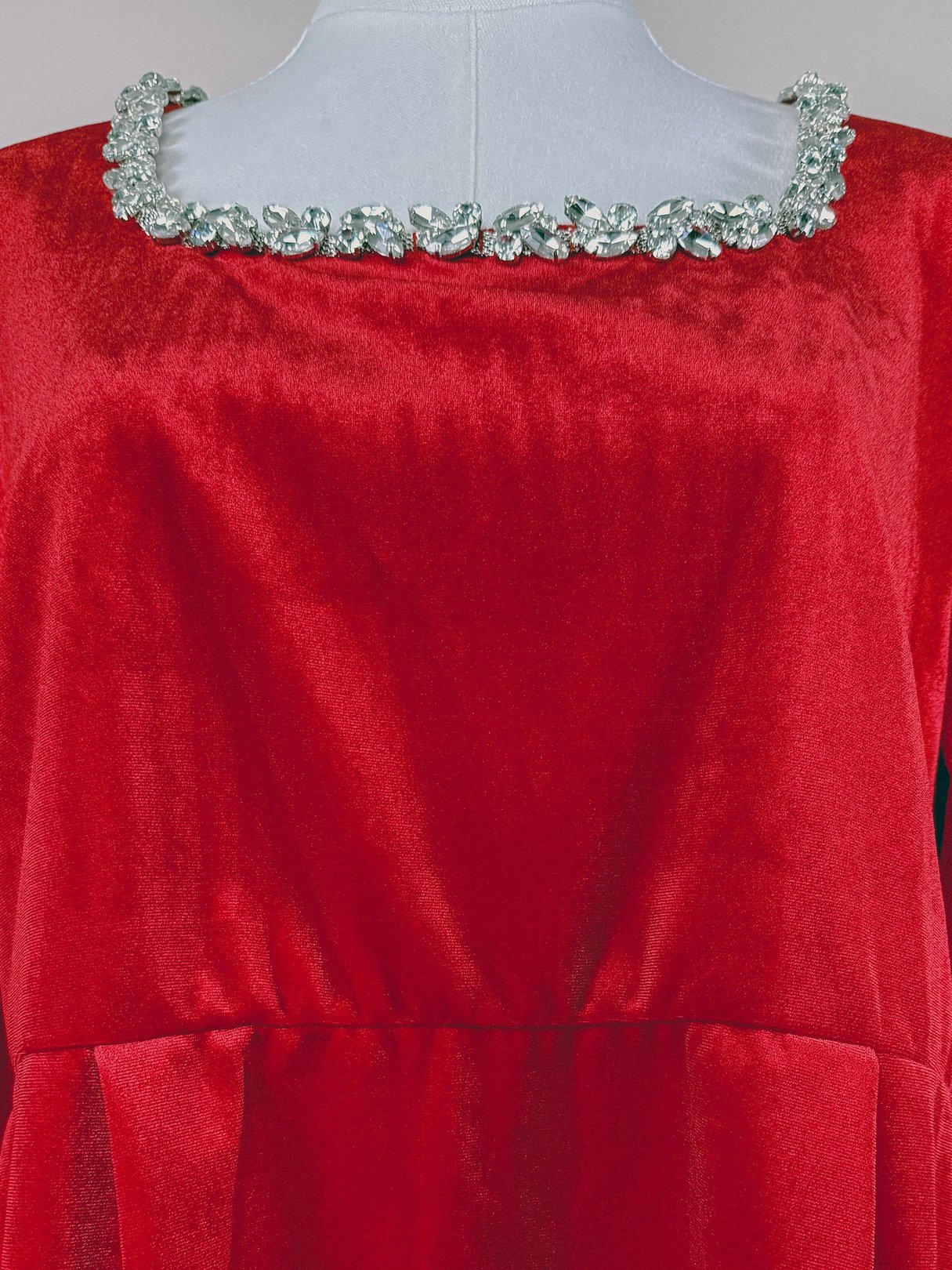 Red velvet fabric featuring a smooth, luxurious texture, suitable for a 1970s women's dress.