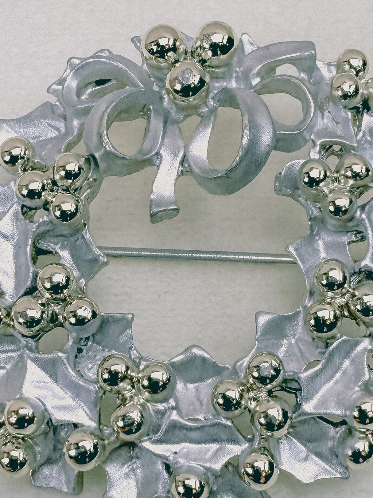 Silver 1970s Keepsake Wreath Brooch featuring a decorative holly design with spherical accents.