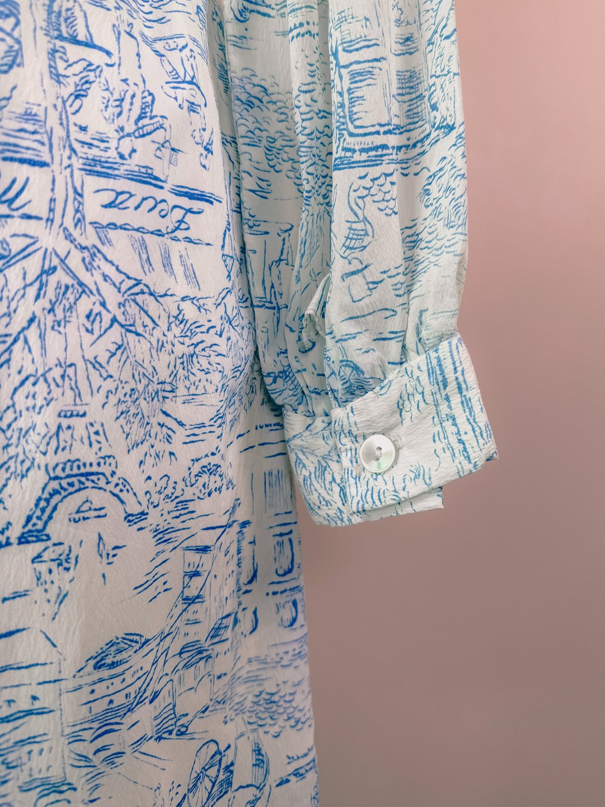 Blue 1960s women’s dress featuring a printed montage design and buttoned cuff details.