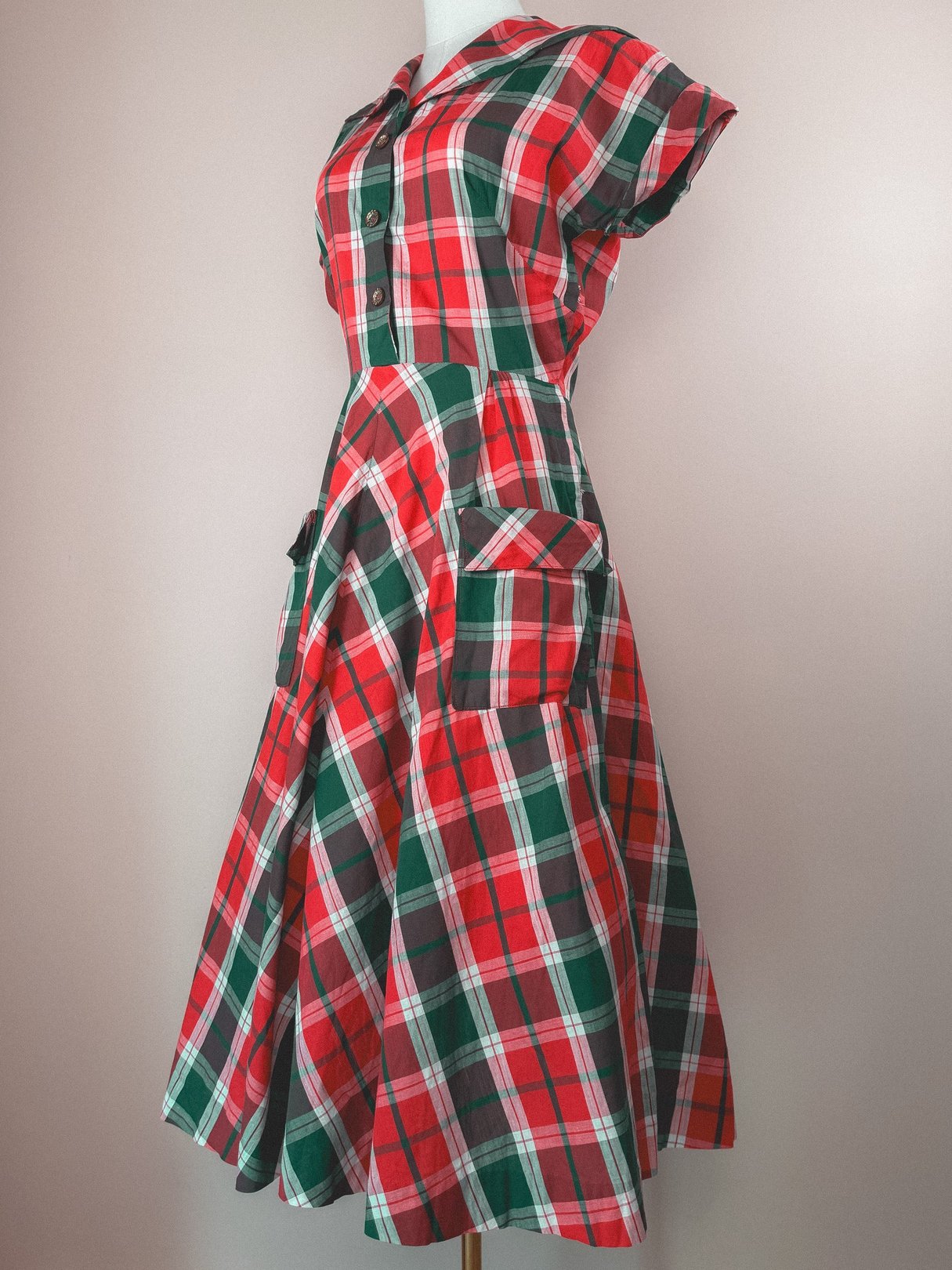 1950s women's red and green plaid dress featuring a collar, short sleeves, and large front pockets.