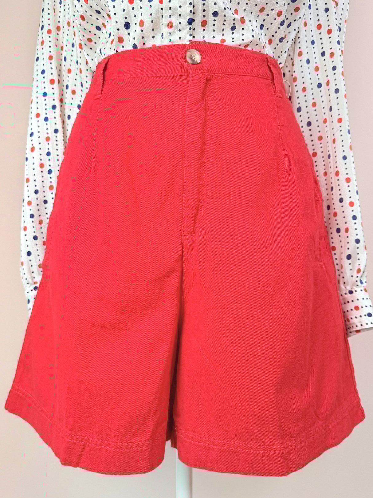 Red high-waisted women's shorts from the 1980s, featuring a button closure and a wide-leg style.