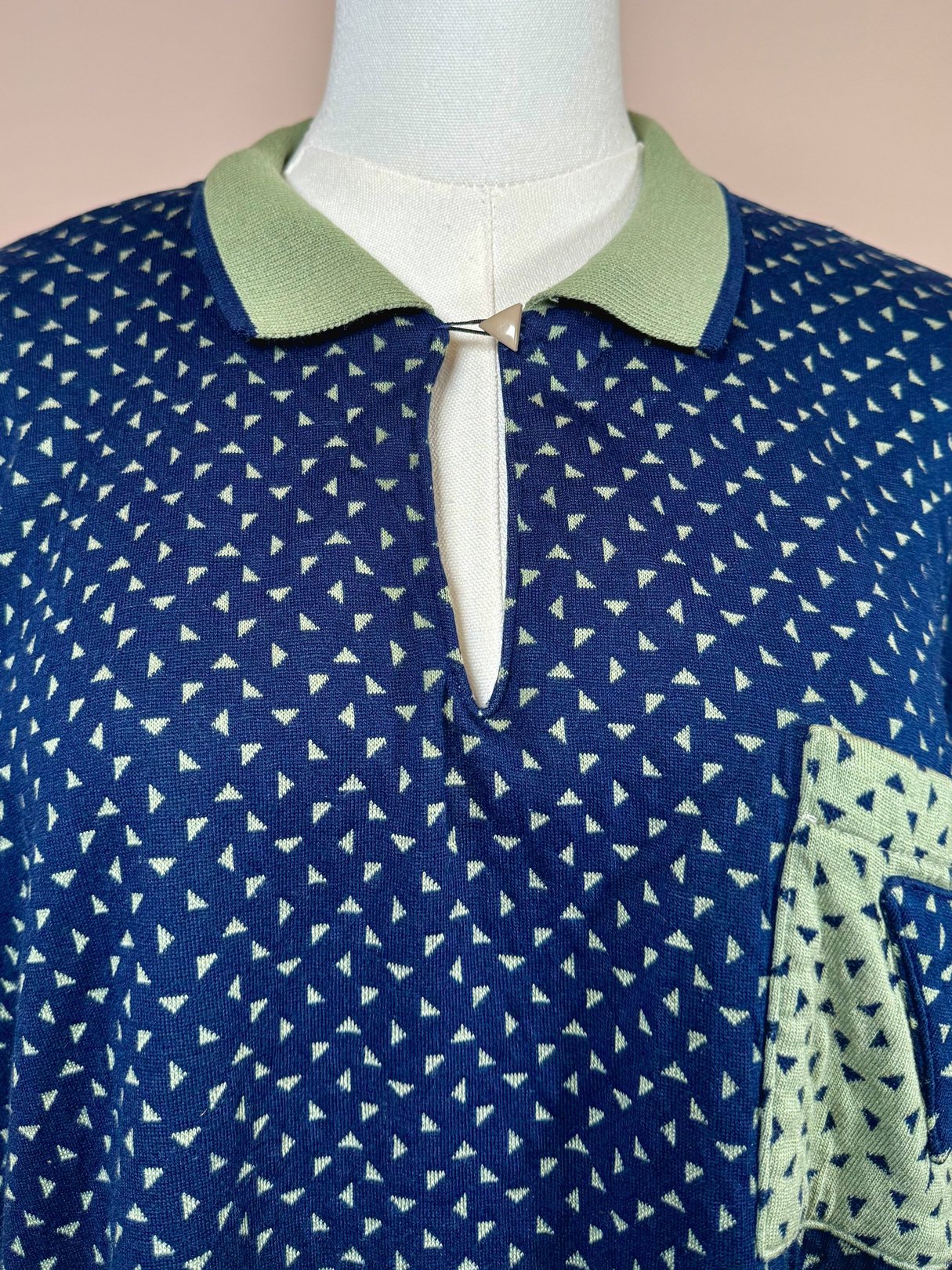 Navy blue triangle-patterned women's top from the 1980s featuring a collar and a front pocket.
