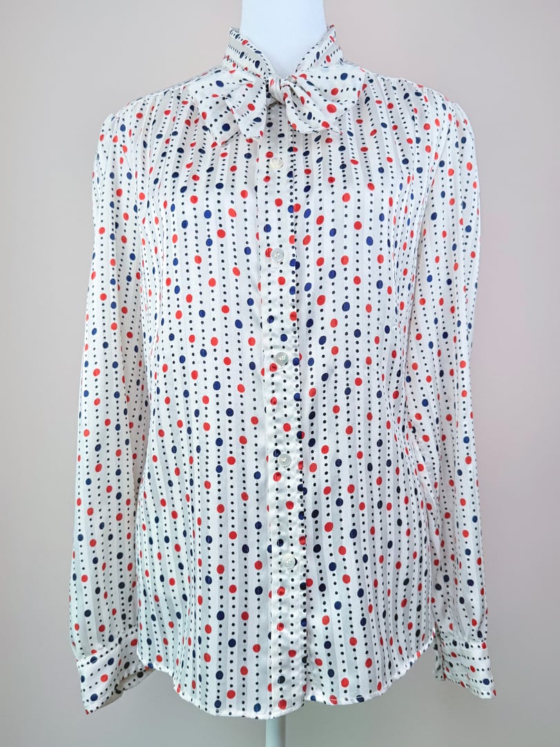 A women's blouse from the 1980s in red, white, and blue with a polka dot pattern and a bow tie collar.