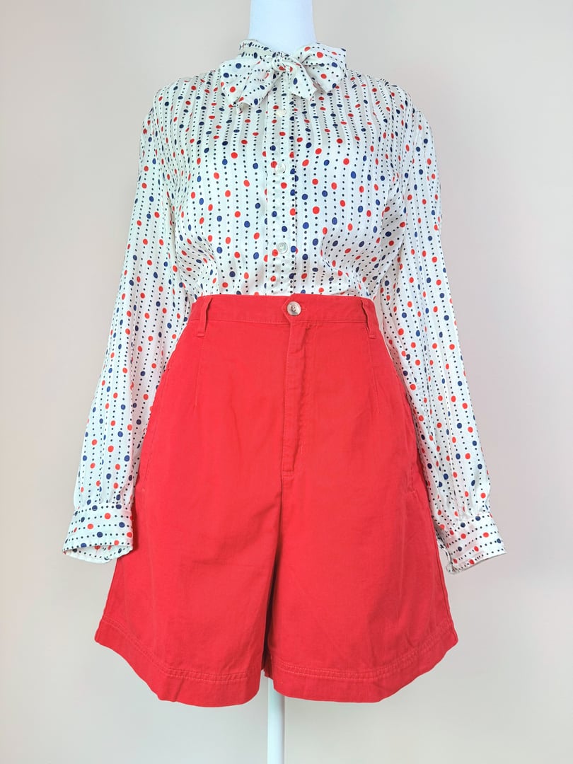High-waisted red vintage shorts styled with a polka dot blouse, showcasing an 1980s fashion aesthetic for women.