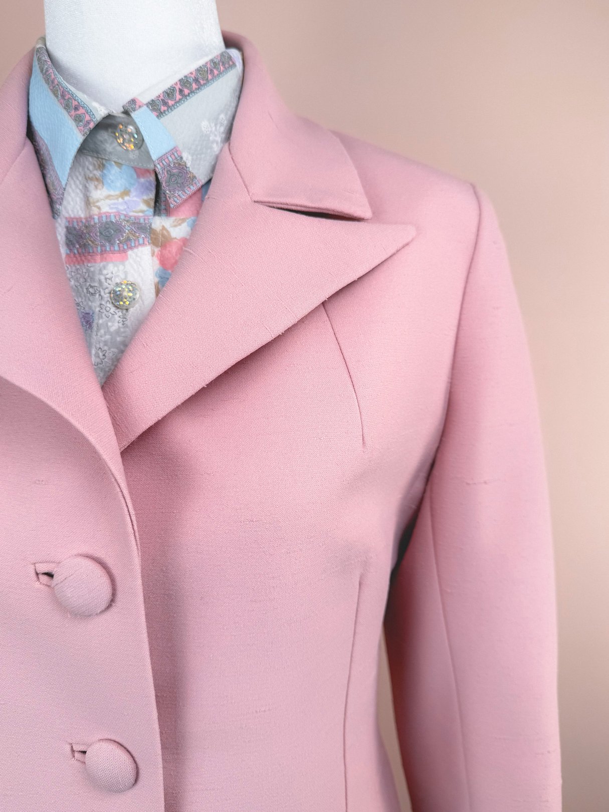 Blush pink women's 1970s Lilli Ann three-piece suit featuring a fitted blazer and a colorful patterned blouse underneath.