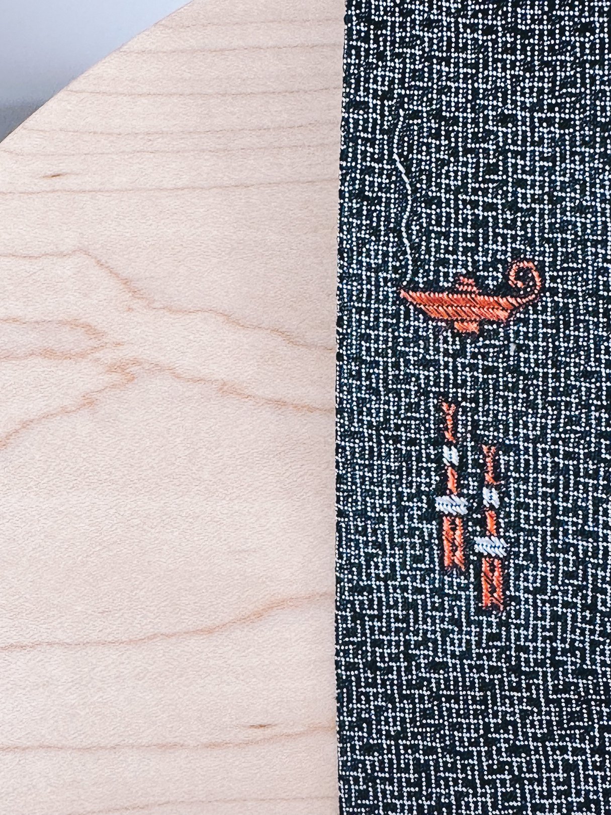 Black skinny tie featuring a graphic design of a genie lamp and smoke, inspired by the 1950s.