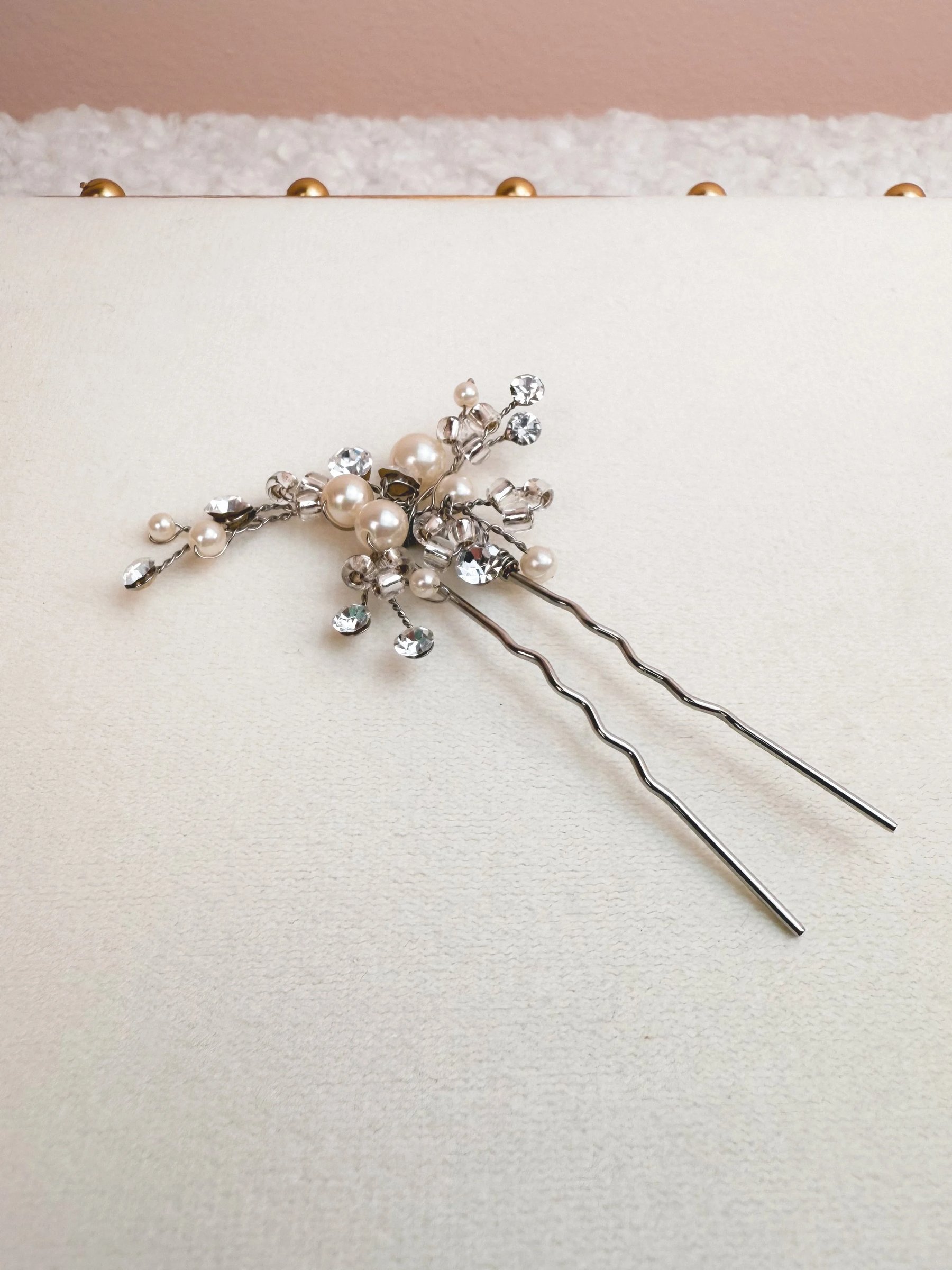 Silver hairpins adorned with pearls and rhinestones.