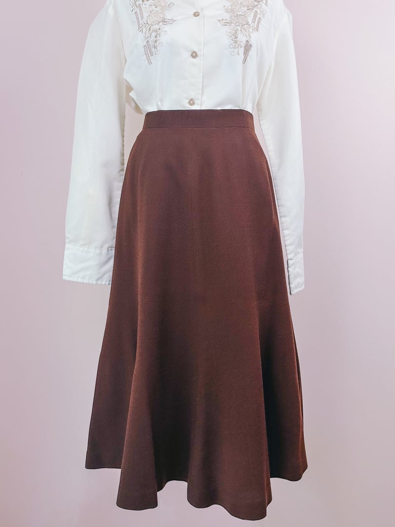 A brown 1970s women's skirt styled with a white embroidered blouse.