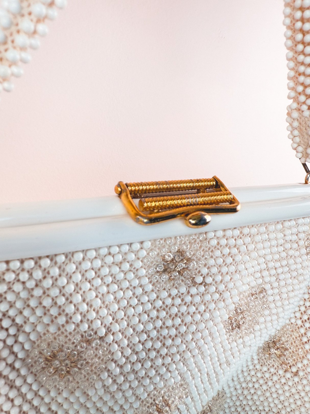 Cream white 1950s-style handbag embellished with sparkly detailing and a gold clasp, designed for women.
