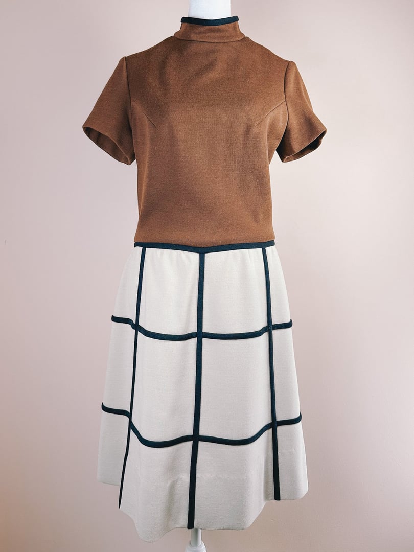 Brown short-sleeve dress featuring a high collar and a squared patterned skirt, reflecting 1960s British Mod style.