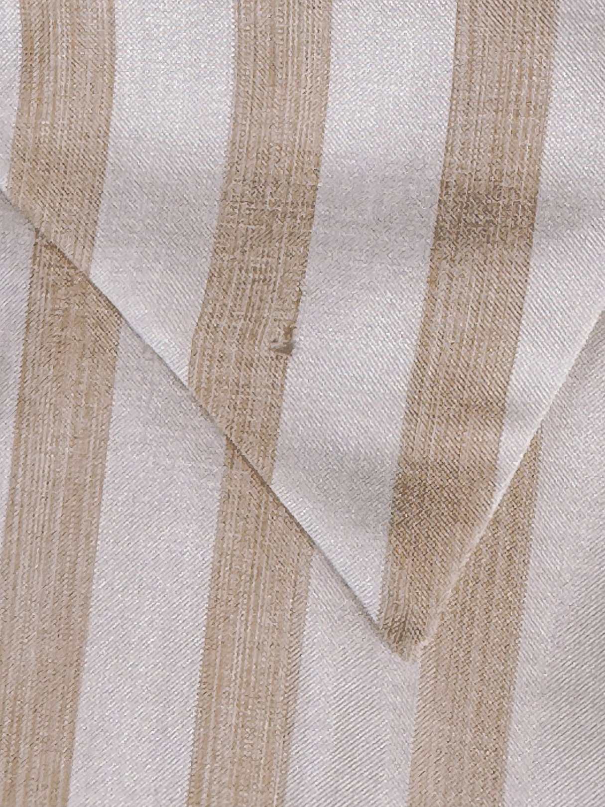A close-up of a Chic 1970s striped blouse featuring classic retro white with tan and blush stripes.
