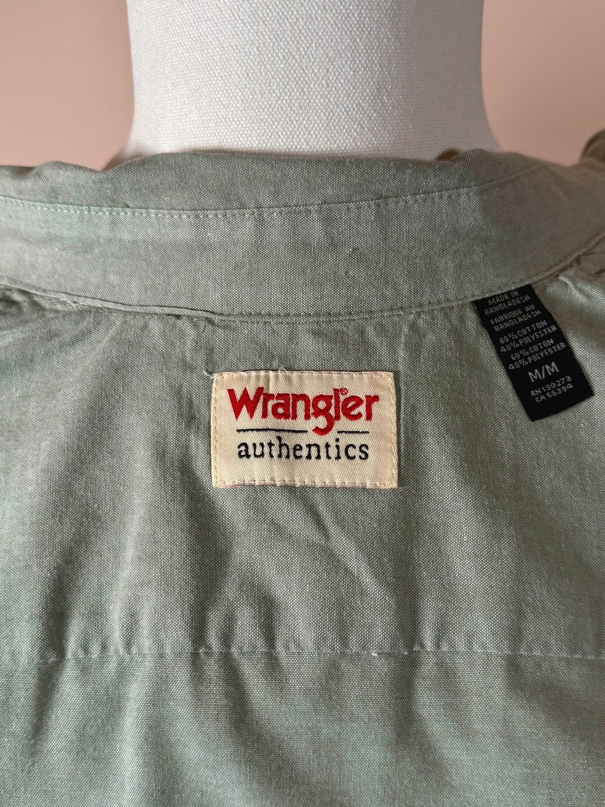 Sage green Wrangler Authentics camp shirt for men, featuring a visible brand label on the back.
