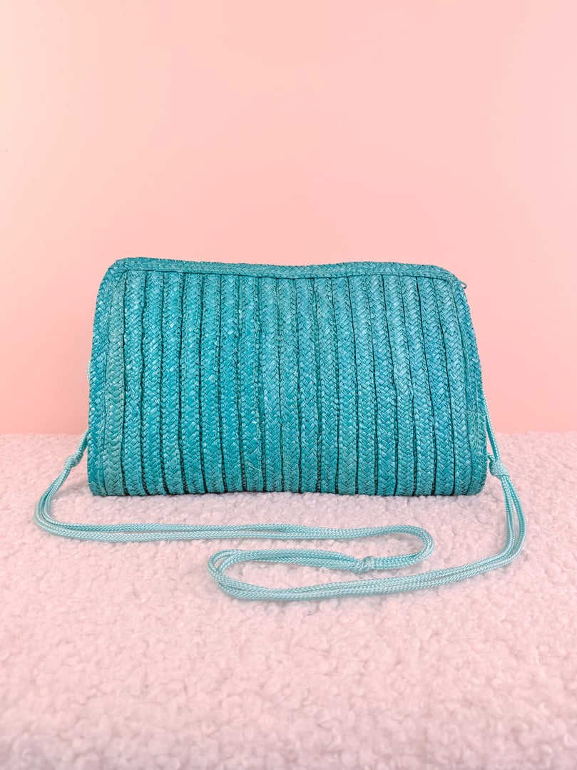 Teal blue 1970s-inspired shoulder bag with a textured, ribbed design and a long strap.