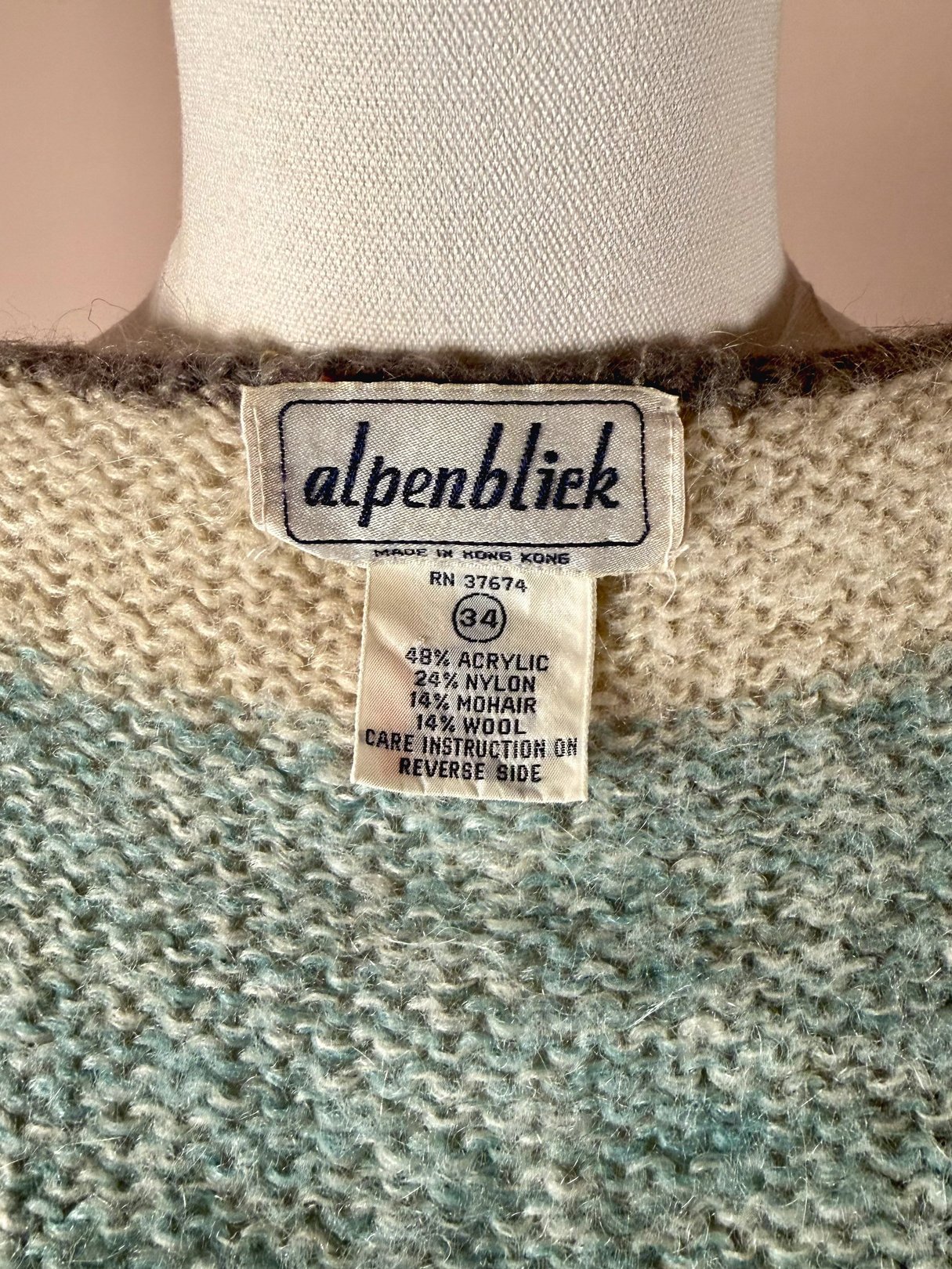 Light blue 1970s women's mohair sweater vest with a label indicating fabric composition and care instructions.