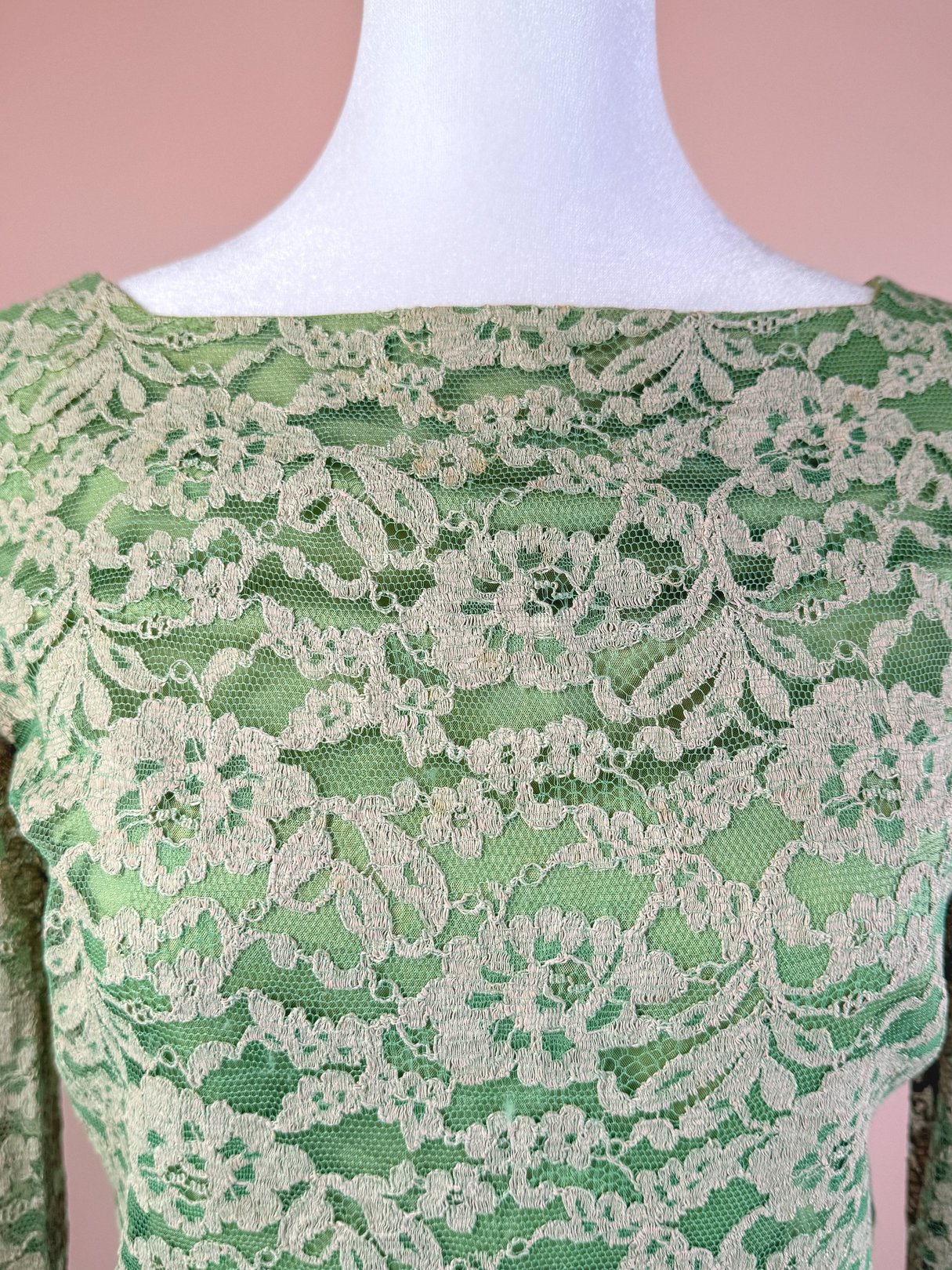 Seafoam green 1960s lace dress featuring a boat neckline and long sleeves.