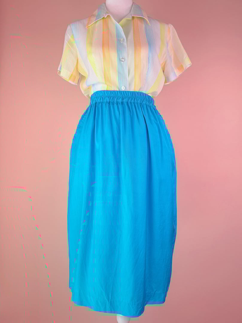 Turquoise blue 1980s women's Bodega Bay skirt with a high waist and elastic waistband, paired with a short-sleeve pastel striped shirt.