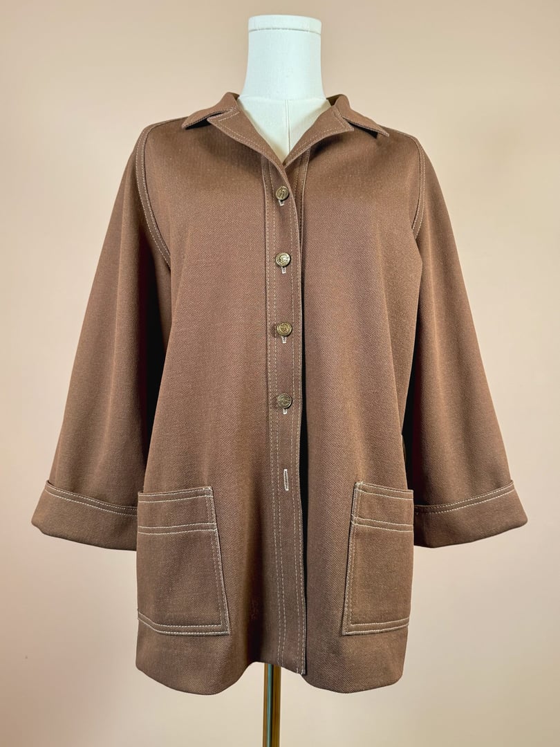 Chestnut brown women's jacket from the 1960s featuring a collared neckline, button-down front, and two patch pockets.