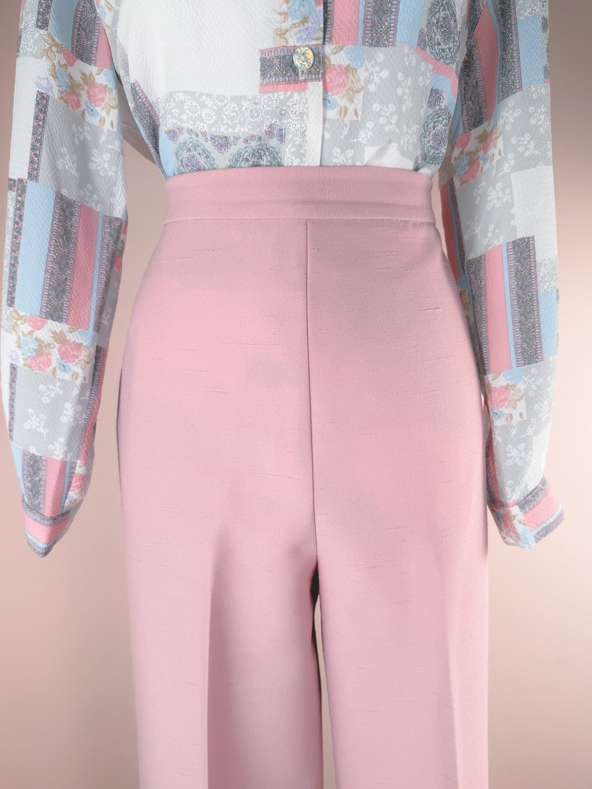 The Lilli Ann Blush Moment 3 Piece Suit features a blush pink skirt and tailored pants with a patterned blouse from the 1970s, designed for women.